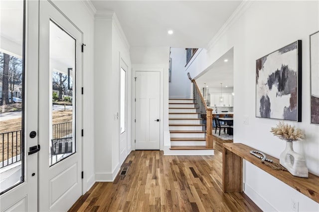 entrance foyer featuring crown molding, recessed lighting, visible vents, stairway, and wood finished floors