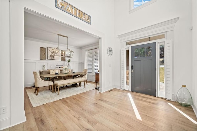 foyer entrance featuring light hardwood / wood-style floors and crown molding