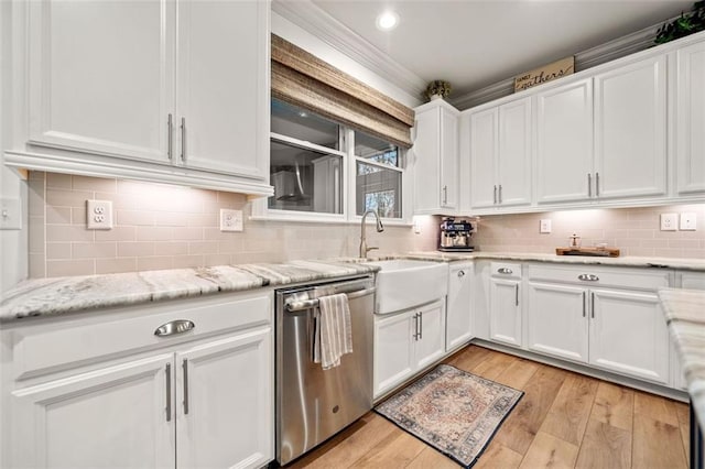 kitchen featuring light stone countertops, stainless steel dishwasher, sink, light hardwood / wood-style flooring, and white cabinets