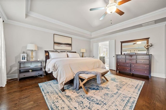 bedroom with ensuite bath, ceiling fan, dark hardwood / wood-style flooring, a tray ceiling, and ornamental molding