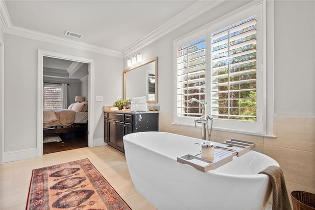 bathroom featuring a bathing tub, a healthy amount of sunlight, and ornamental molding