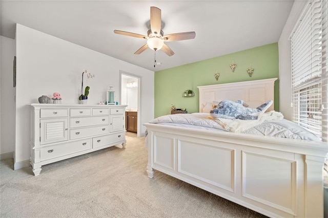 bedroom with light colored carpet, ceiling fan, and ensuite bathroom