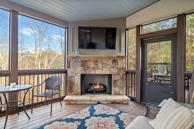 sunroom featuring a fireplace, vaulted ceiling, and wood ceiling