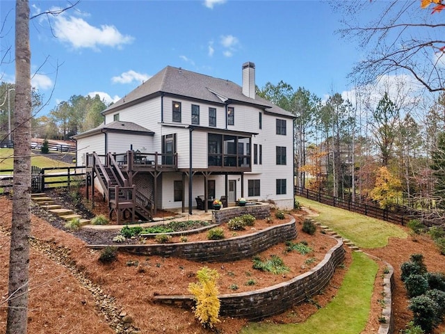 rear view of property featuring a sunroom and a deck