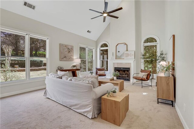 living room with plenty of natural light, light colored carpet, and high vaulted ceiling