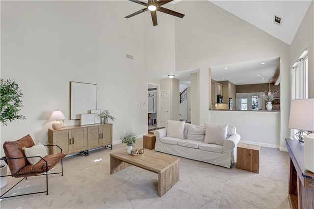 living room with a high ceiling and light carpet