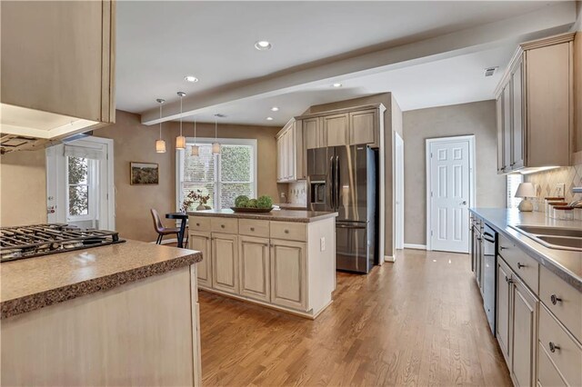 kitchen with stainless steel fridge with ice dispenser, cream cabinets, and hanging light fixtures