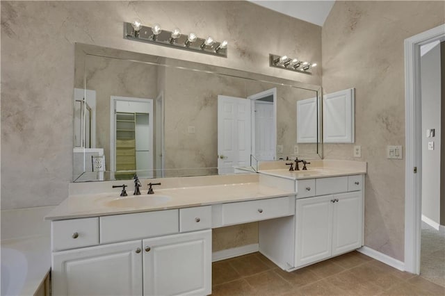 bathroom with tile patterned floors, a bathtub, and vanity