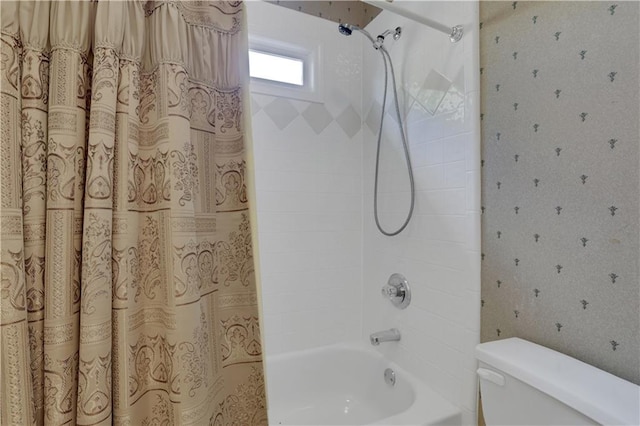 bathroom featuring shower / bathtub combination with curtain and toilet