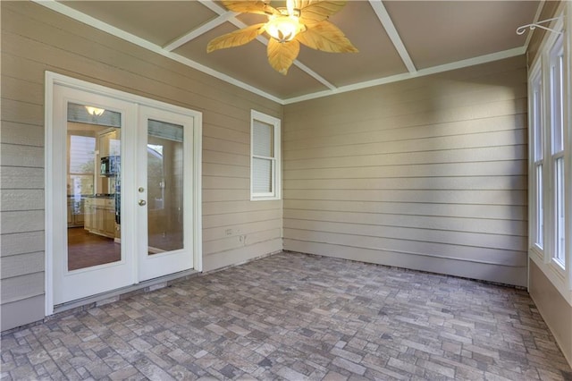 unfurnished sunroom featuring ceiling fan and french doors