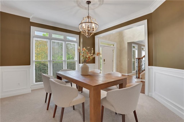 dining space featuring light carpet, crown molding, and a chandelier