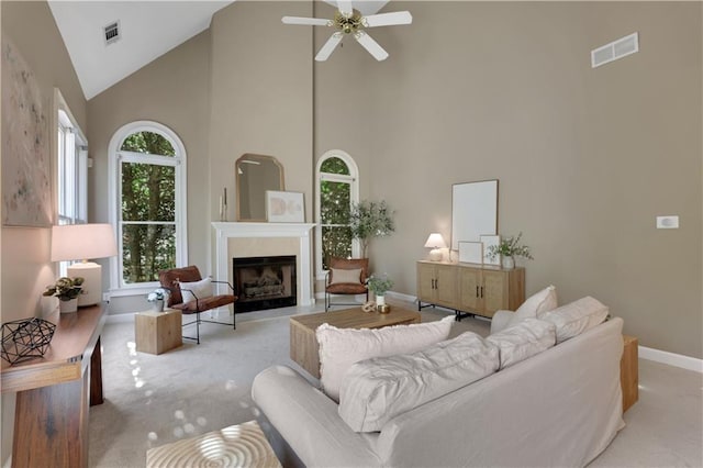 carpeted living room featuring ceiling fan, high vaulted ceiling, and a healthy amount of sunlight