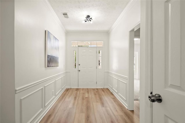 3111 Serenade Ct, Milton, GA 30004 - foyer entrance featuring ornamental molding, light wood finished floors, a decorative wall, wainscoting, and a textured ceiling