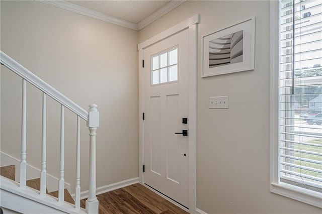 foyer entrance featuring plenty of natural light, wood finished floors, stairway, ornamental molding, and baseboards