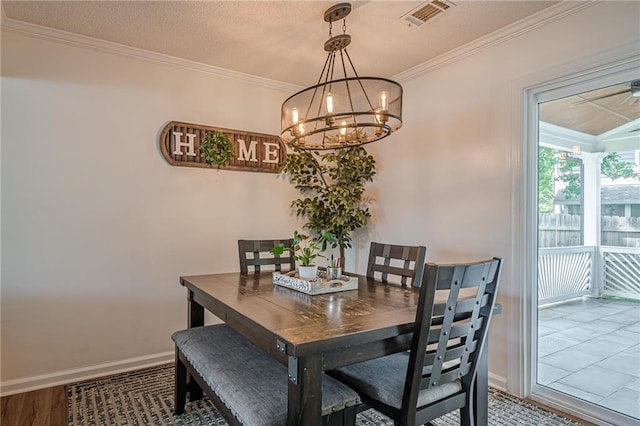 dining area featuring a chandelier, ornamental molding, and baseboards