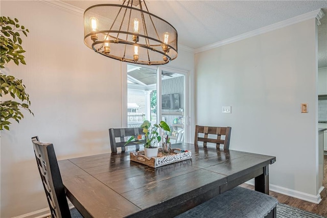dining room with a chandelier, wood finished floors, crown molding, and baseboards