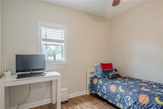 bedroom featuring wood finished floors, baseboards, and a ceiling fan