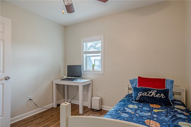 bedroom with wood finished floors, baseboards, and a ceiling fan