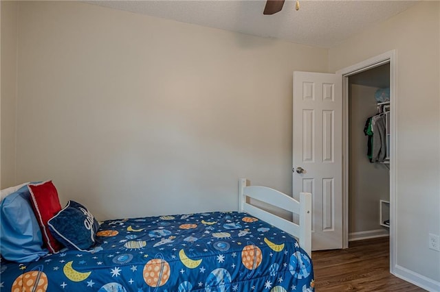 bedroom with wood finished floors, a textured ceiling, ceiling fan, and baseboards