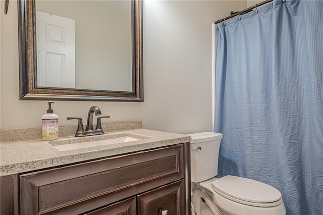 bathroom featuring toilet, vanity, and a shower with shower curtain