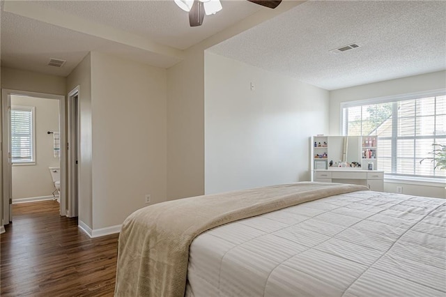 bedroom featuring dark wood-type flooring, a textured ceiling, baseboards, and ceiling fan