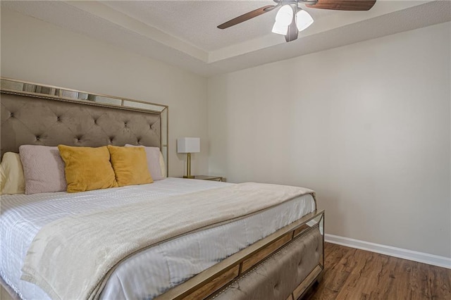 bedroom featuring wood finished floors, baseboards, and a ceiling fan