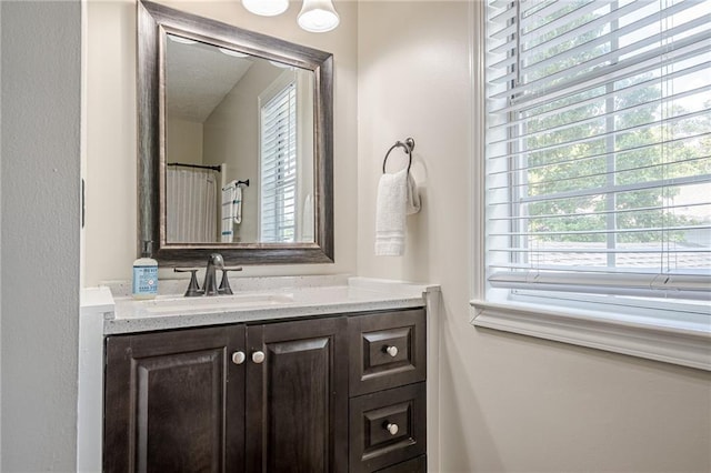 full bathroom with plenty of natural light and vanity