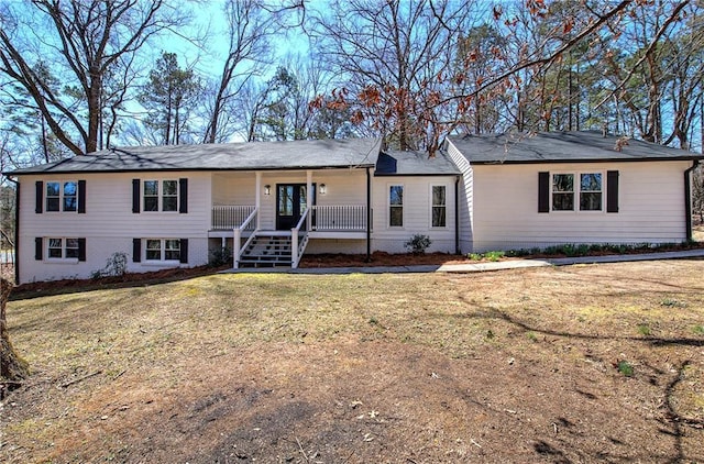 single story home featuring a porch, a front yard, and brick siding