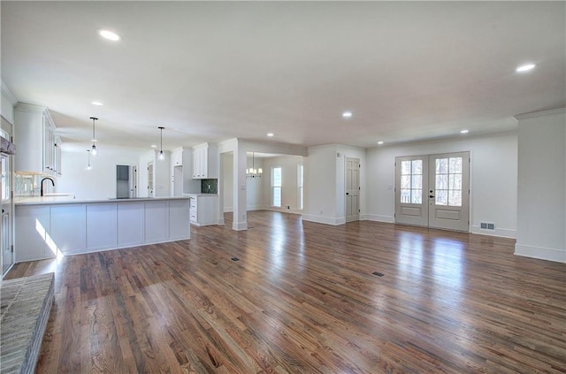 unfurnished living room with dark wood-style floors, recessed lighting, and visible vents