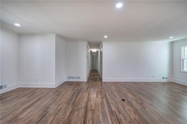 unfurnished room with ornamental molding, visible vents, baseboards, and wood finished floors