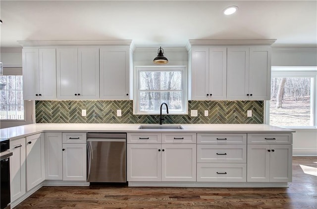 kitchen featuring ornamental molding, stainless steel dishwasher, a sink, and white cabinets