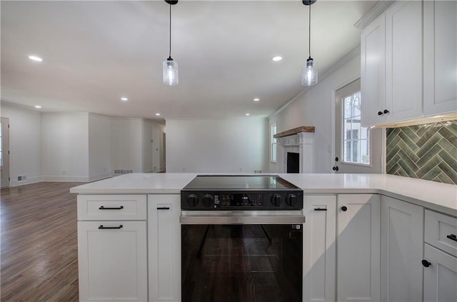 kitchen with tasteful backsplash, open floor plan, light countertops, and range with electric stovetop