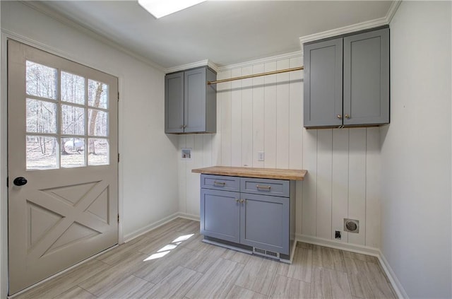 clothes washing area featuring hookup for a washing machine, cabinet space, light wood-style floors, and baseboards