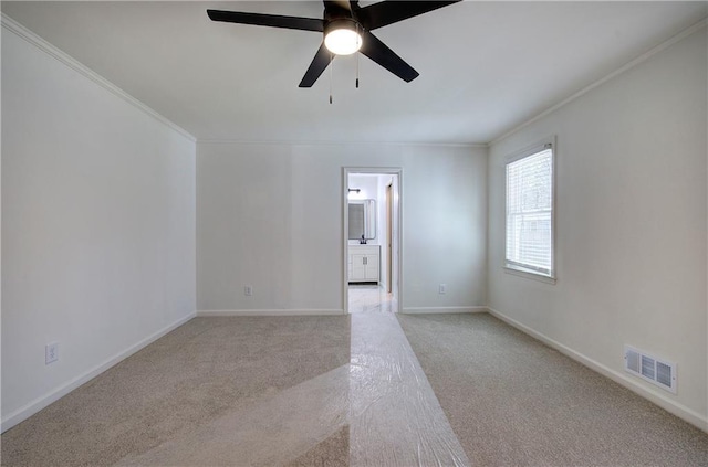 spare room with light carpet, visible vents, and crown molding