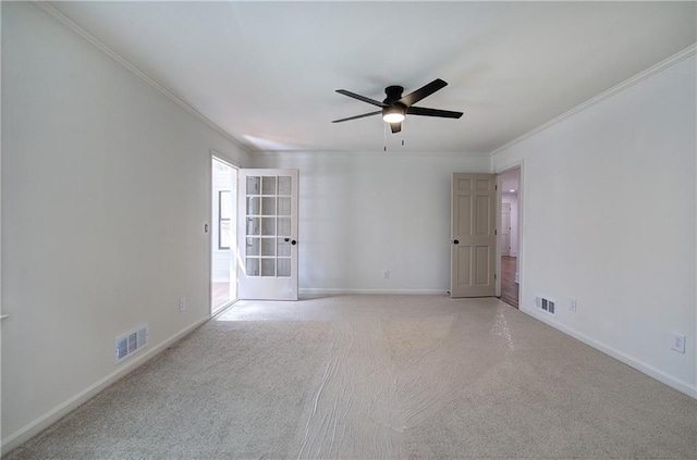 unfurnished room with baseboards, visible vents, light colored carpet, and ornamental molding