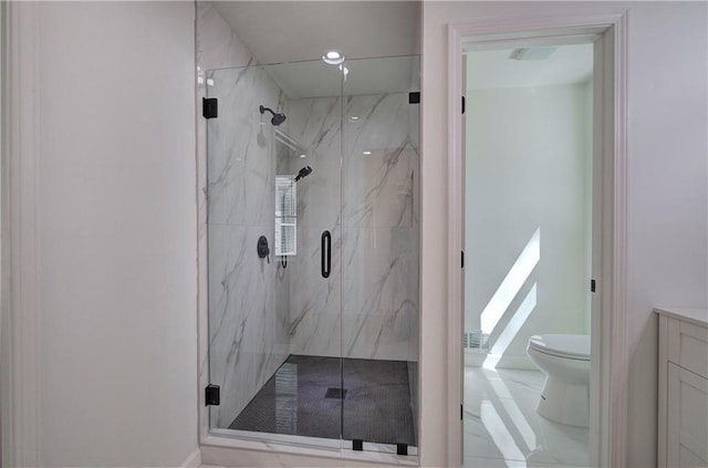 bathroom with a marble finish shower, vanity, and toilet