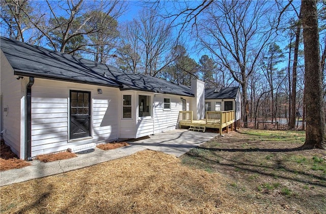 exterior space with a patio area, a deck, and a yard