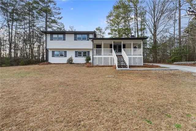 split level home featuring a porch and a front lawn