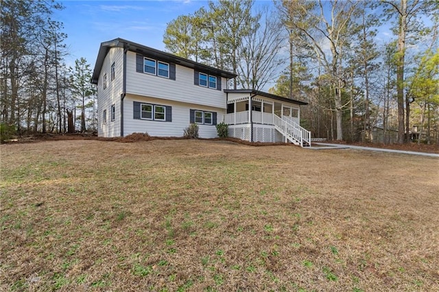 rear view of property featuring a porch and a yard