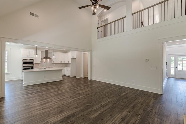 4075 O Henry Ct, Mcdonough, GA 30252 - unfurnished living room featuring a towering ceiling, dark wood-style flooring, a ceiling fan, baseboards, and a sink