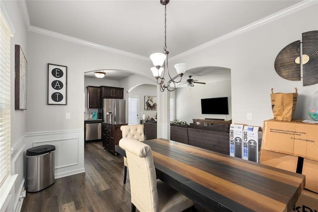 3406 Pennington Dr, Lithonia, GA 30038 - dining space featuring arched walkways, ornamental molding, dark wood-type flooring, a ceiling fan, and a wainscoted wall