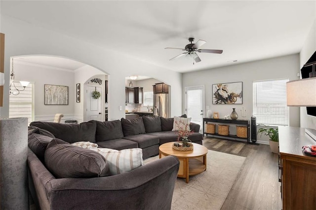 3406 Pennington Dr, Lithonia, GA 30038 - living area featuring arched walkways, a ceiling fan, wood finished floors, crown molding, and a chandelier