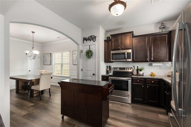 3406 Pennington Dr, Lithonia, GA 30038 - kitchen with appliances with stainless steel finishes, decorative backsplash, dark wood-style floors, and crown molding
