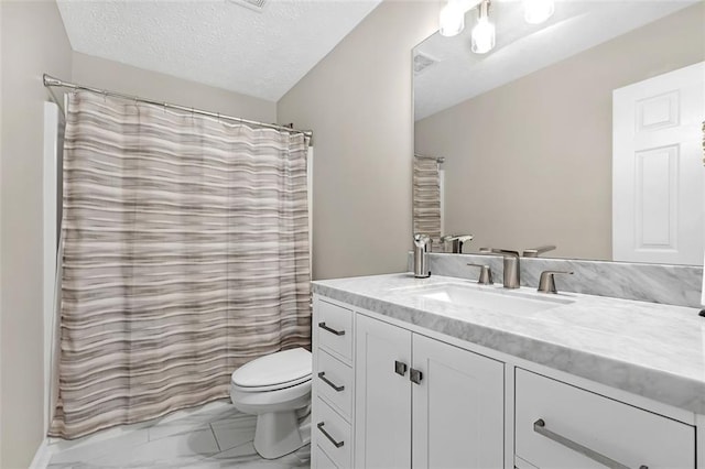 bathroom with vanity, toilet, and a textured ceiling