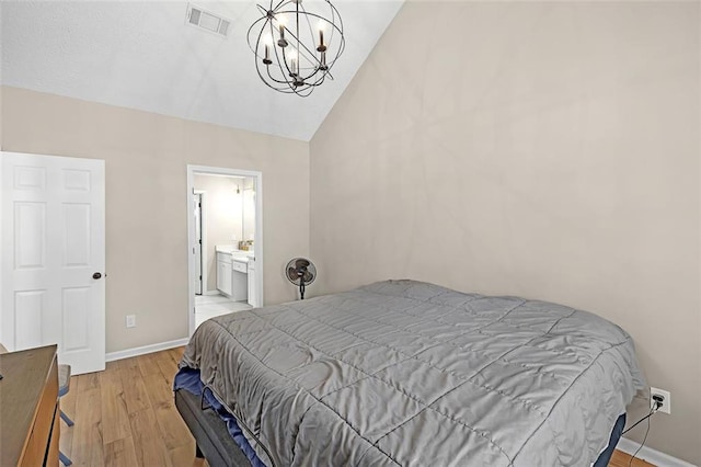 bedroom featuring lofted ceiling, a notable chandelier, and light wood-type flooring