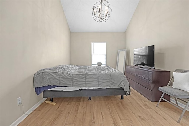 bedroom featuring light hardwood / wood-style flooring, vaulted ceiling, and a chandelier