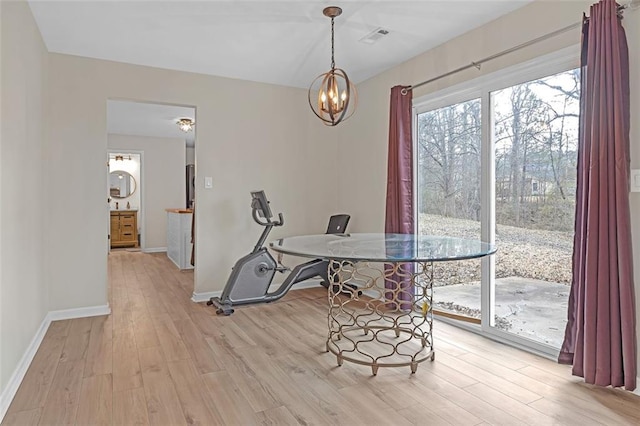 dining area with an inviting chandelier and light hardwood / wood-style floors