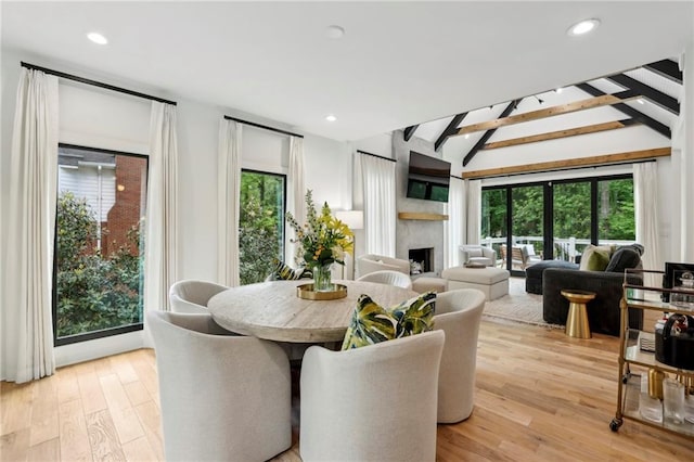 dining space featuring a fireplace, light wood-style floors, and recessed lighting
