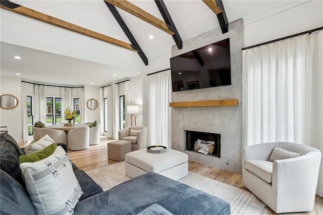 living area featuring beam ceiling, light wood finished floors, a fireplace, high vaulted ceiling, and recessed lighting