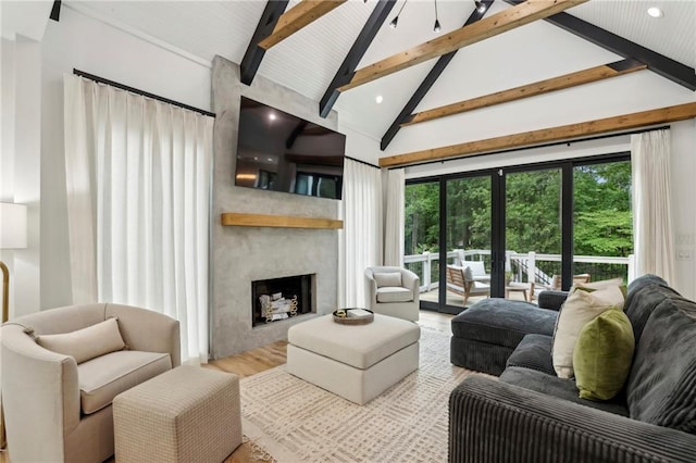 living area with beamed ceiling, a fireplace, high vaulted ceiling, and wood finished floors
